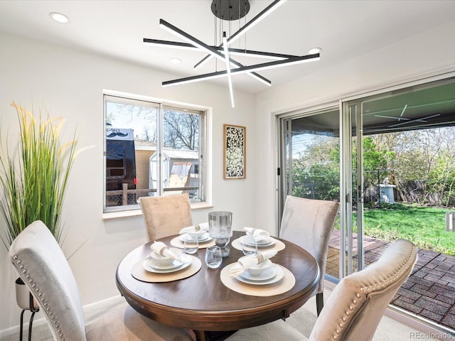 carpeted dining space with an inviting chandelier