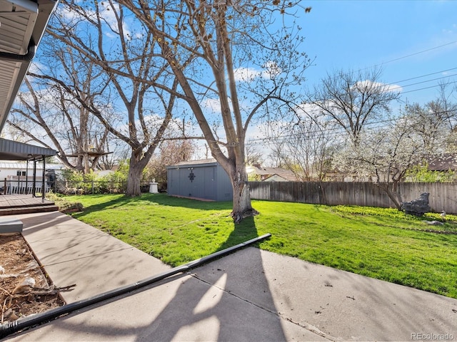 view of yard with a patio area, a storage shed, and a wooden deck