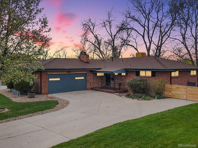 ranch-style home with a garage and a lawn