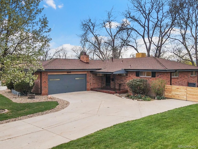 ranch-style house with a garage and a front lawn