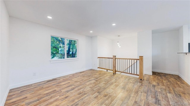 empty room with light wood-style floors, recessed lighting, and baseboards