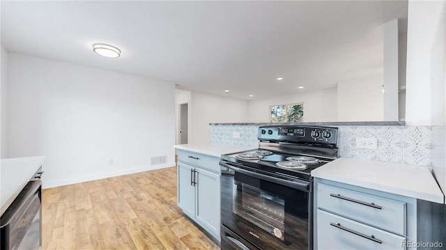 kitchen with black range with electric cooktop, visible vents, light wood-style floors, light countertops, and stainless steel dishwasher