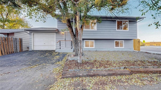 view of front of property featuring driveway and fence