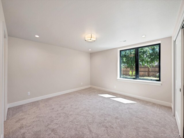 unfurnished room featuring light colored carpet