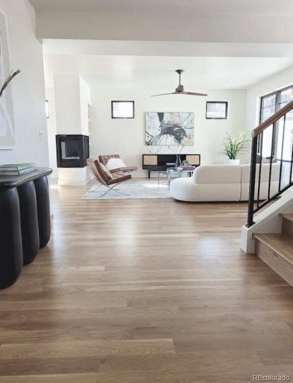 living room featuring wood-type flooring and ceiling fan