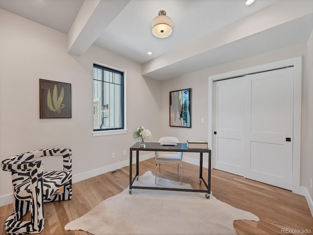 home office featuring beam ceiling and light wood-type flooring