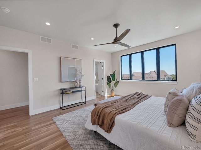 bedroom featuring ensuite bath, ceiling fan, and light hardwood / wood-style floors