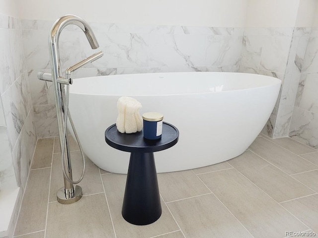 bathroom with tile patterned flooring and a tub to relax in