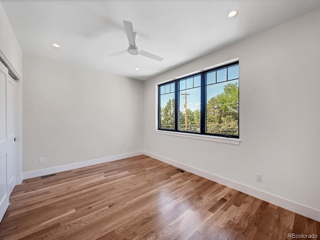 empty room with ceiling fan and hardwood / wood-style floors