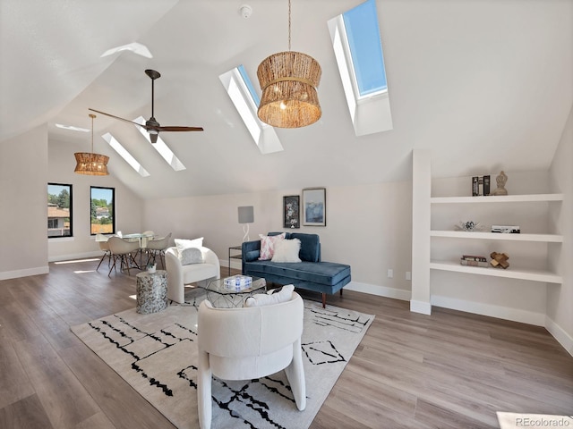 living room with lofted ceiling, ceiling fan with notable chandelier, wood-type flooring, and built in shelves