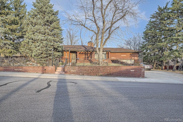 view of front of home with brick siding and a chimney