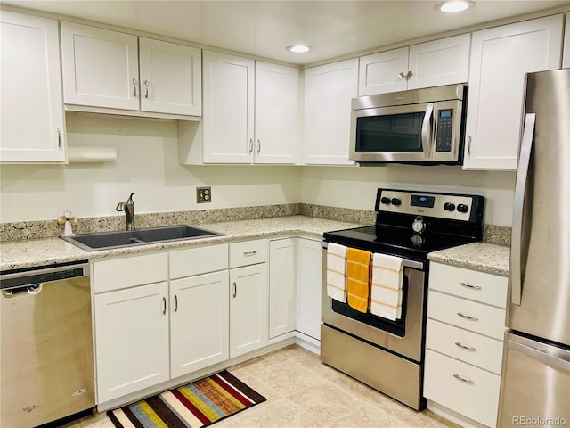 kitchen featuring white cabinets, appliances with stainless steel finishes, and sink