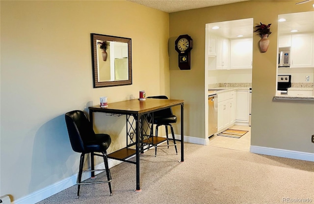 carpeted dining space with a textured ceiling