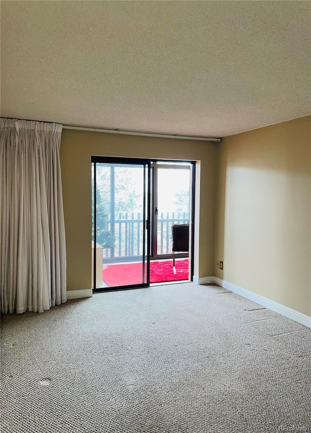 carpeted spare room featuring a textured ceiling