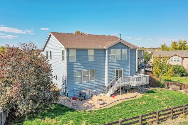 back of house featuring a lawn, a deck, and a patio