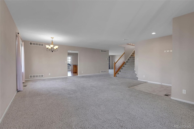 empty room featuring light carpet and a chandelier