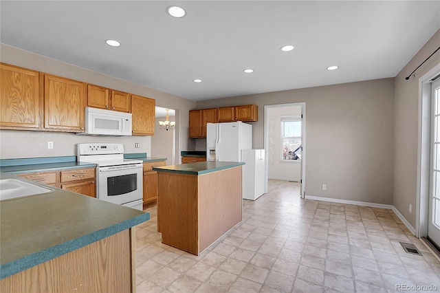 kitchen with white appliances, a kitchen island, and sink