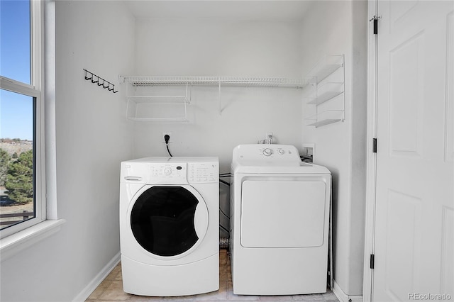 clothes washing area featuring washing machine and dryer and light tile patterned floors