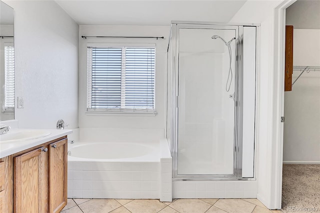 bathroom featuring shower with separate bathtub, vanity, and tile patterned floors