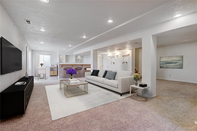 carpeted living room featuring a textured ceiling