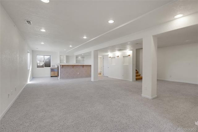 unfurnished living room featuring light carpet and a textured ceiling