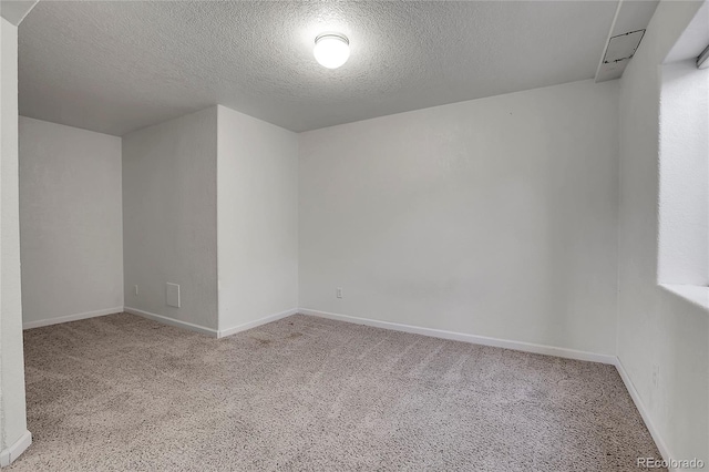 carpeted empty room featuring a textured ceiling