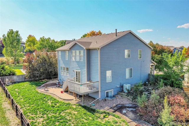 back of property featuring a lawn and a wooden deck