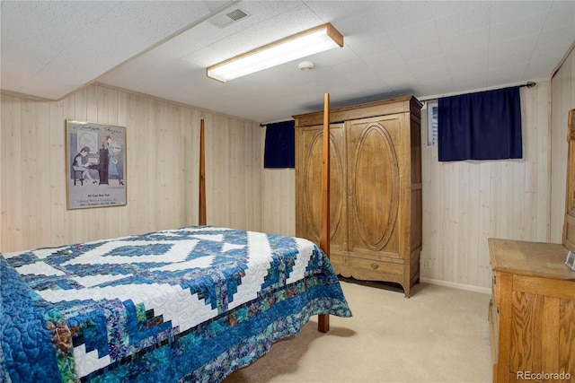 carpeted bedroom featuring wood walls