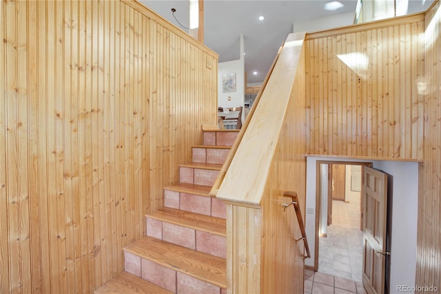 staircase featuring wood walls