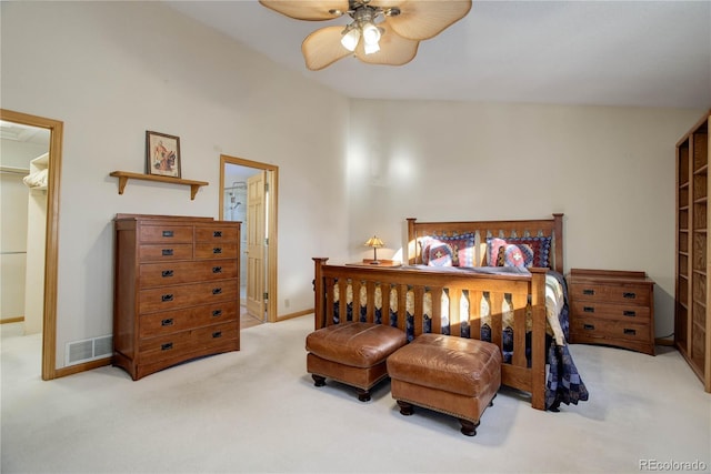 carpeted bedroom with ceiling fan, a closet, a spacious closet, and vaulted ceiling