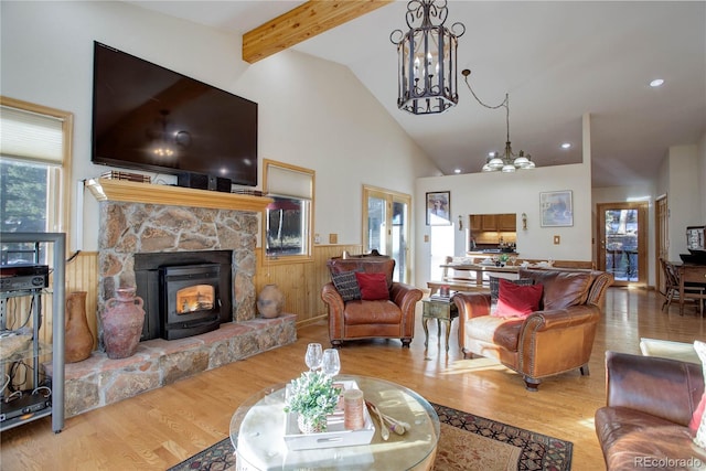 living room with beamed ceiling, light wood-type flooring, a fireplace, and high vaulted ceiling