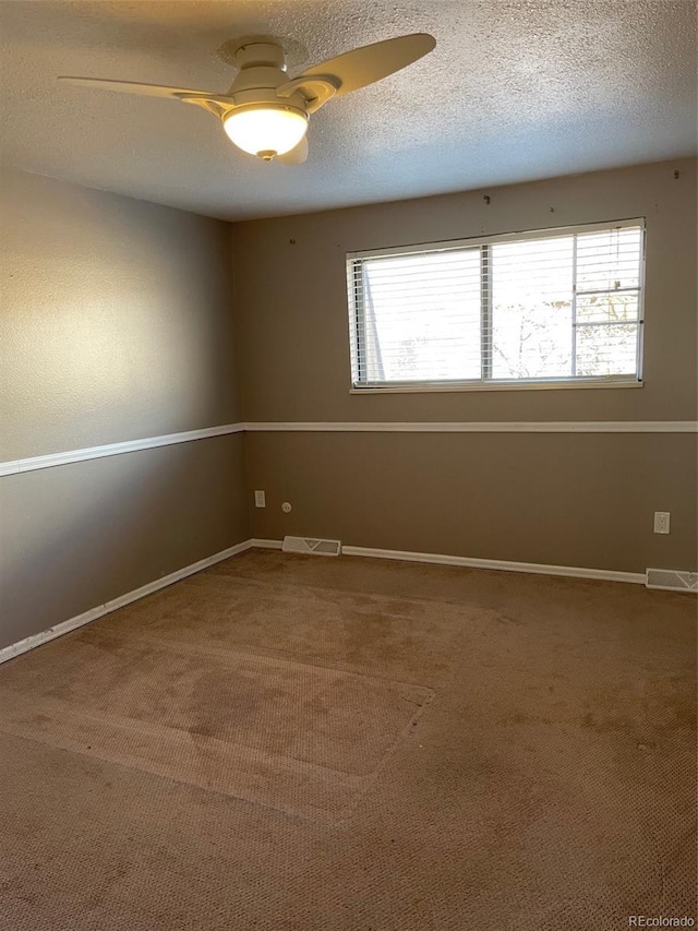 spare room with ceiling fan, carpet, and a textured ceiling