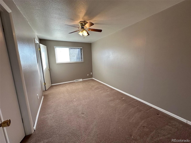 carpeted empty room with a textured ceiling and ceiling fan