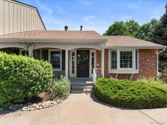 7101 W Yale Ave Unit 1305, Denver, CO 80227 - property entrance featuring brick siding, board and batten siding, roof with shingles, and a porch