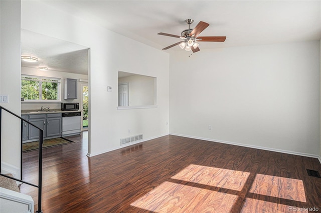 spare room with dark wood-type flooring, ceiling fan, and sink