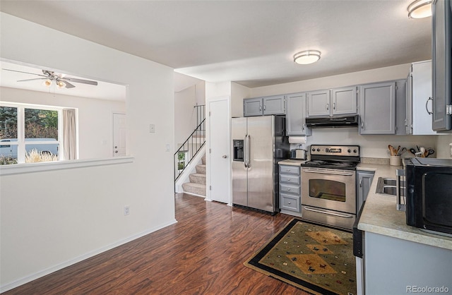 kitchen with dark wood-type flooring, ceiling fan, appliances with stainless steel finishes, and gray cabinets