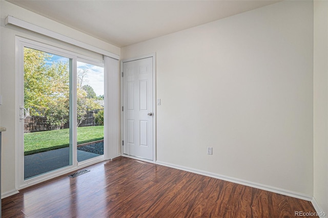 empty room with dark hardwood / wood-style flooring