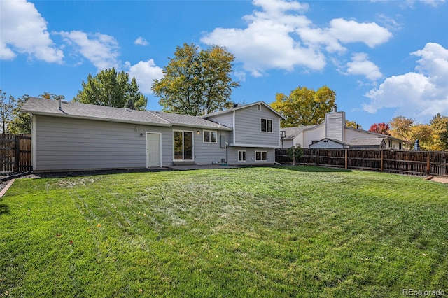 rear view of house with a yard and a patio