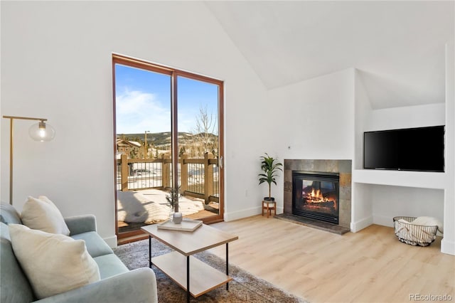 living room with high vaulted ceiling, a fireplace, and hardwood / wood-style floors