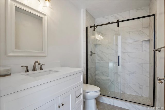 bathroom with vanity, a shower with door, and toilet