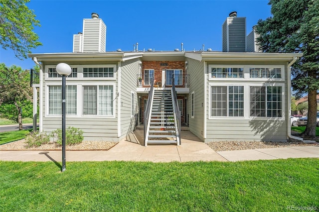 4076 S Carson St Unit H, Aurora, CO 80014 - back of property featuring a chimney, stairway, and a yard