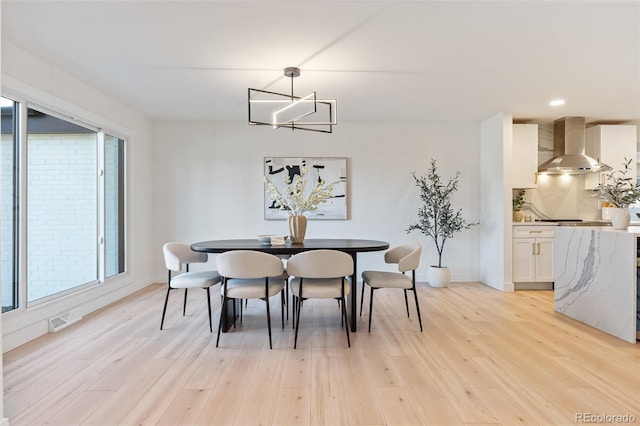 dining room with light hardwood / wood-style flooring and plenty of natural light