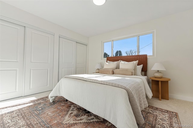 bedroom with carpet floors and multiple closets