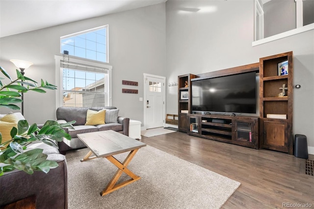 living room with high vaulted ceiling and wood-type flooring