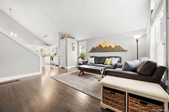 living room with dark hardwood / wood-style flooring and vaulted ceiling