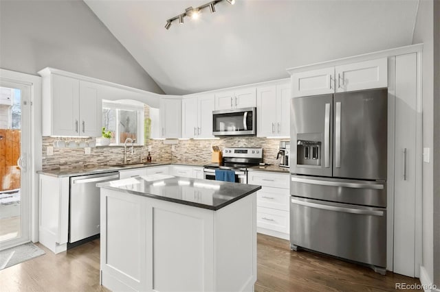 kitchen featuring a center island, backsplash, white cabinets, appliances with stainless steel finishes, and sink