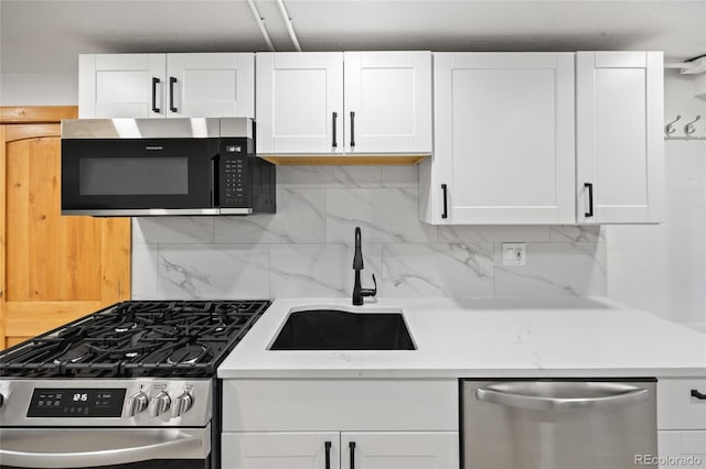 5012 W 36th Ave Unit 5, Denver, CO 80212 - kitchen featuring stainless steel appliances, a sink, light countertops, white cabinetry, and tasteful backsplash