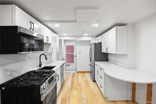 5012 W 36th Ave Unit 5, Denver, CO 80212 - kitchen featuring appliances with stainless steel finishes, a sink, white cabinetry, tasteful backsplash, and recessed lighting