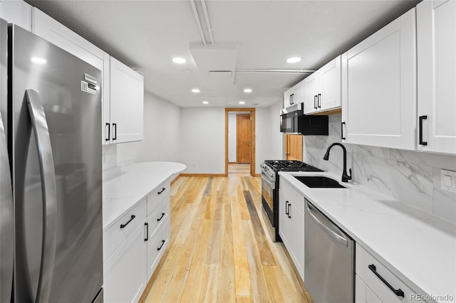 5012 W 36th Ave Unit 5, Denver, CO 80212 - kitchen featuring stainless steel appliances, a sink, recessed lighting, light wood finished floors, and white cabinets