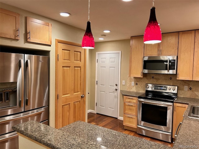 kitchen with pendant lighting, dark hardwood / wood-style flooring, stainless steel appliances, and tasteful backsplash